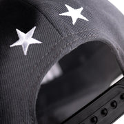Black cap with white star patterns on a blurred background