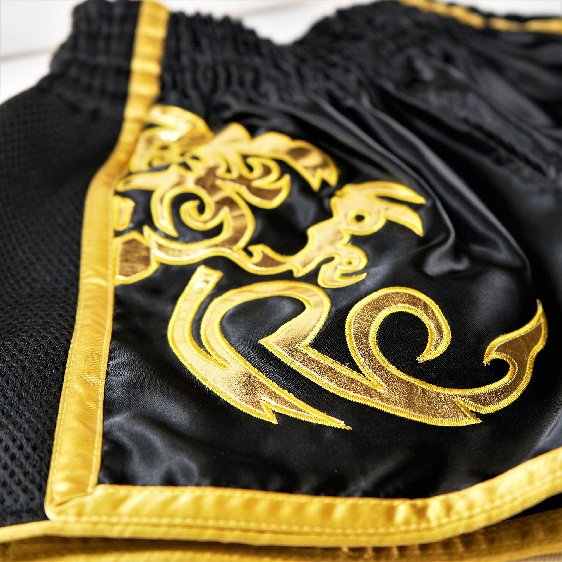 Legacy Golden Era Muay Thai shorts with traditional Thai boxing cut and gold embroidered design
