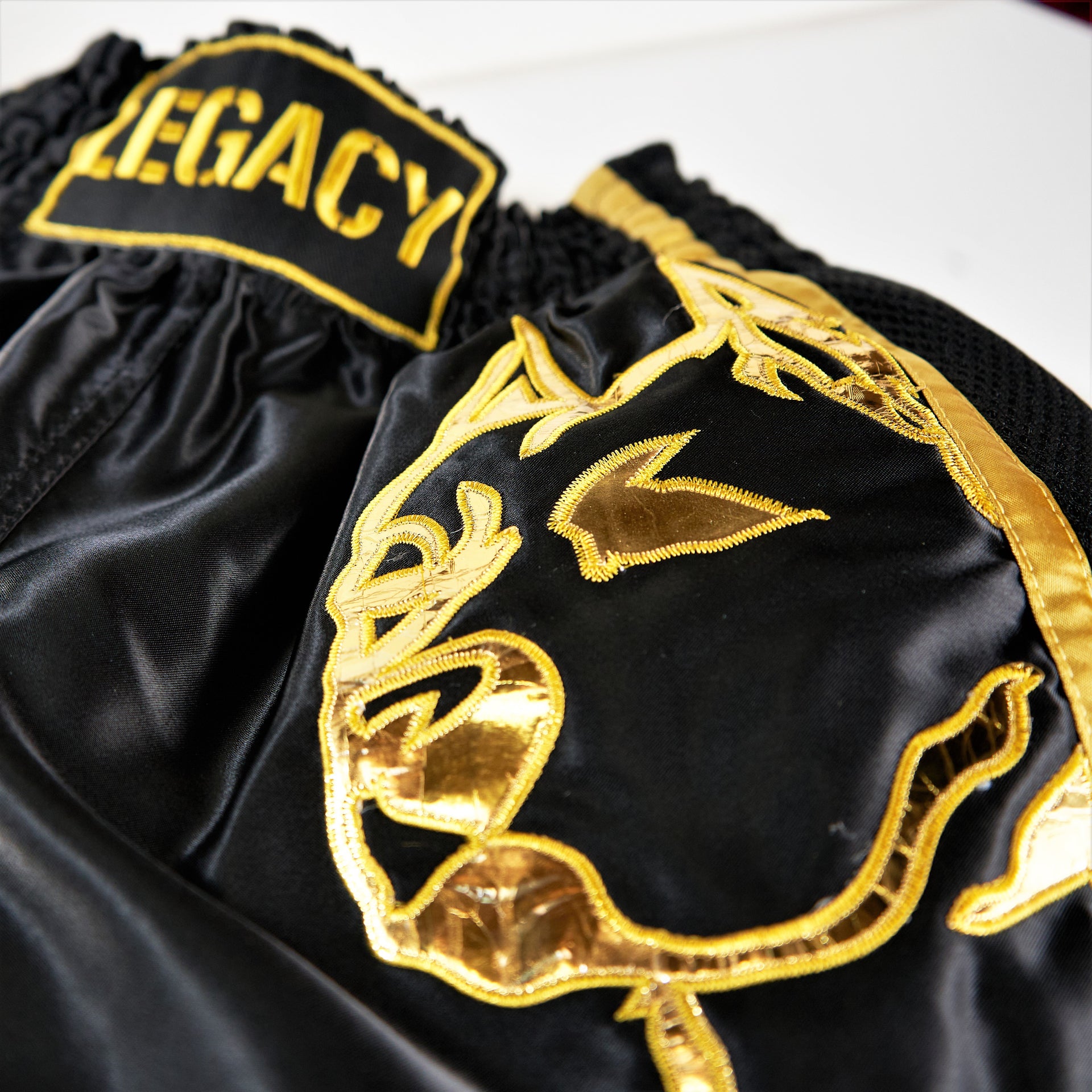 Legacy Golden Era Muay Thai shorts with traditional Thai boxing cut and gold embroidered design