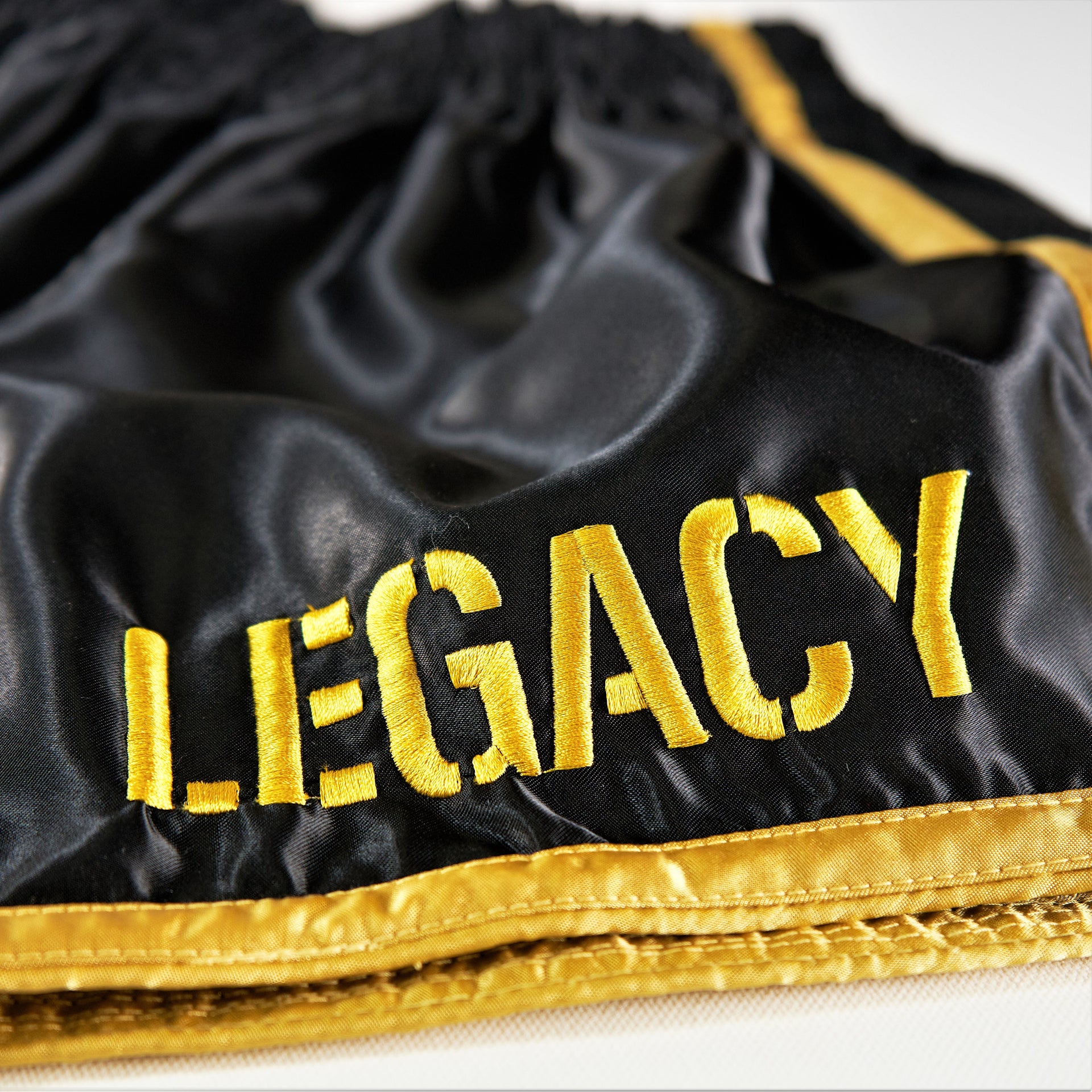 Legacy Golden Era Muay Thai shorts with traditional Thai boxing cut and gold embroidered design
