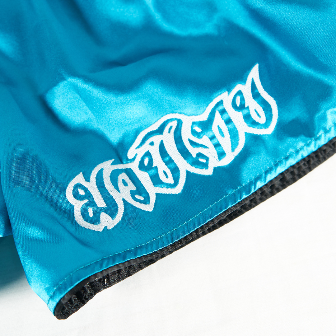 White Dragon Muay Thai shorts with embroidered dragon design and satin finish